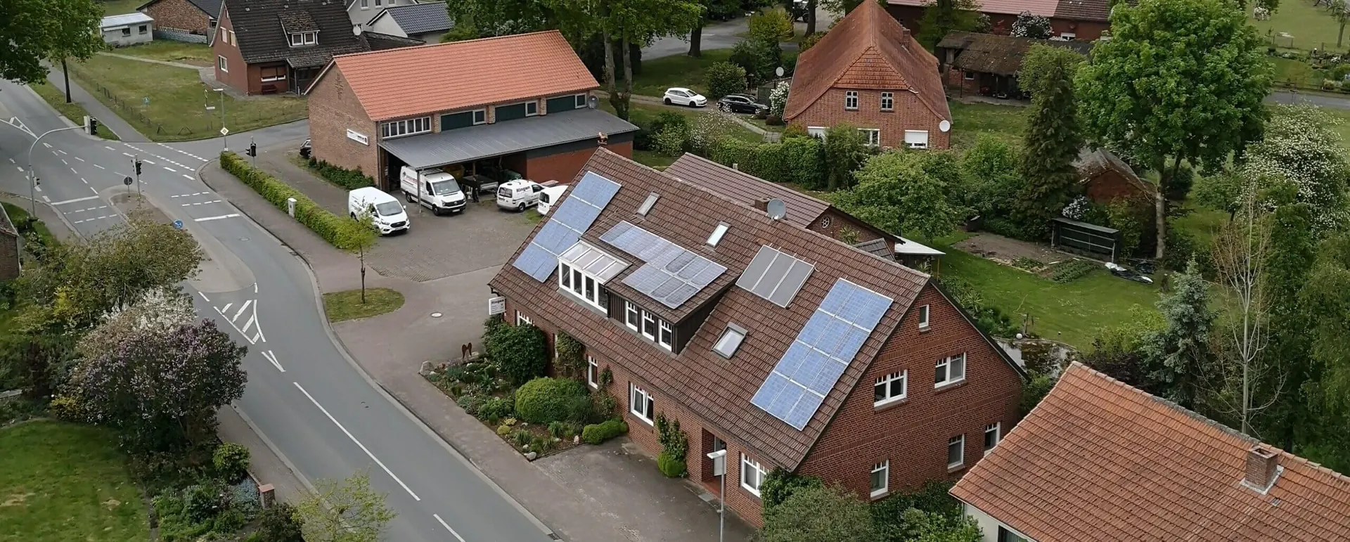 Luftbild des Betriebs an der Landstraße in Ostereistedt mit Wohnhaus, Solaranlage und Werkhalle