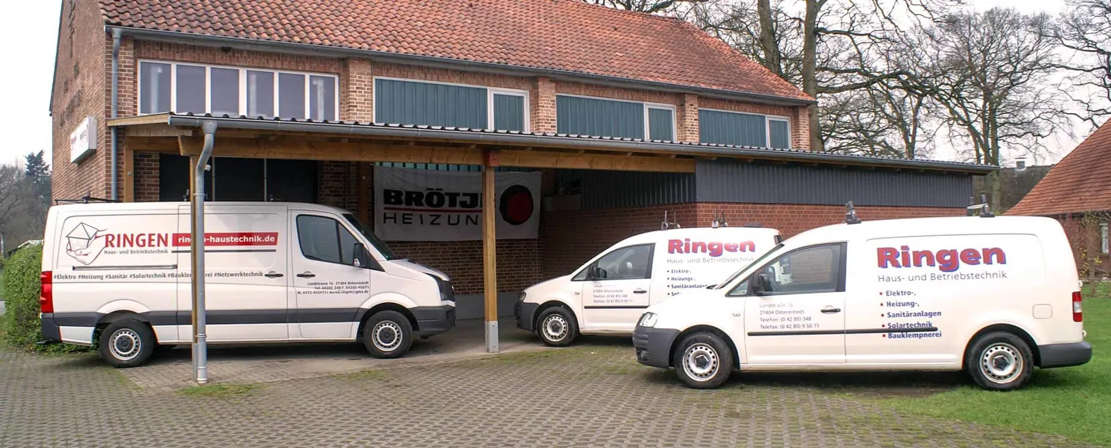 Das Team von Ringen Haus- und Betriebstechnik vor den Firmenwagen und der Werkhalle